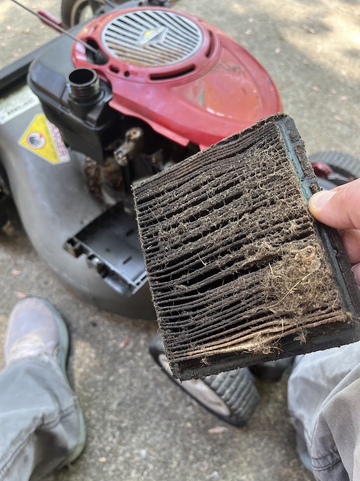 Dirty mower engine filter being shown during service