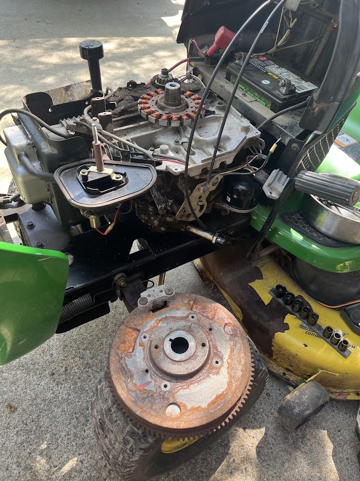 Riding mower repair with engine components removed for service